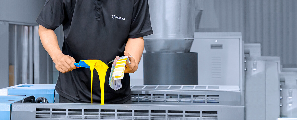 a worker in Kinghorn uniform is checking the yellow ink with a pantone in hand